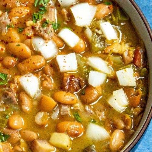 Homemade Soup Beans in a bowl, garnished with chopped white onion
