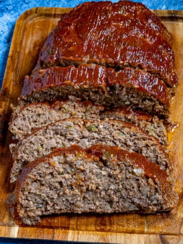 Southern style meatloaf on a cutting board, glazed and sliced, ready to serve