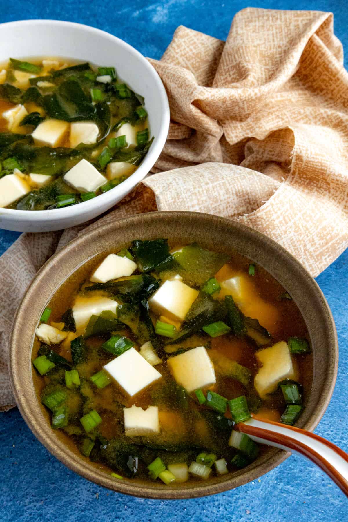 2 bowls of homemade Miso Soup loaded up with tofu, green onion, and seaweed