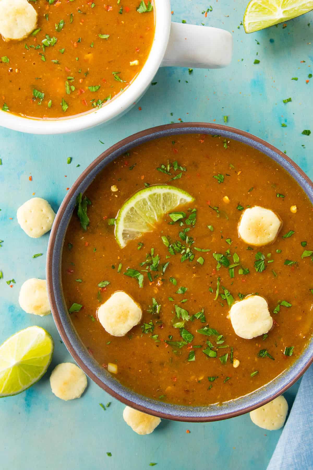 A bowl of cheesy potato soup spiced with guajillo chili paste and more, topped with oyster crackers