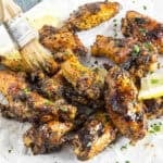 Glazing Lemon Pepper Wings fresh off the grill with a lemon-butter glaze