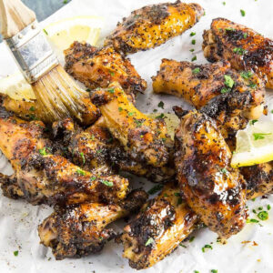Glazing Lemon Pepper Wings fresh off the grill with a lemon-butter glaze