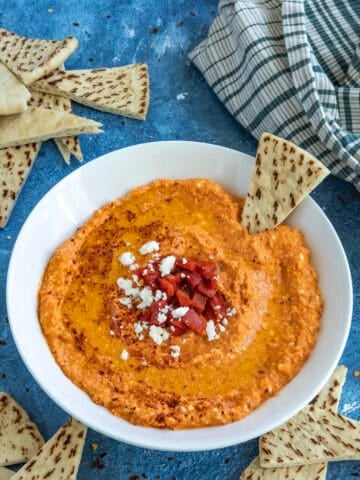 A white bowl filled with creamy Greek Whipped Feta Dip with Roasted Red Peppers (Htipiti)