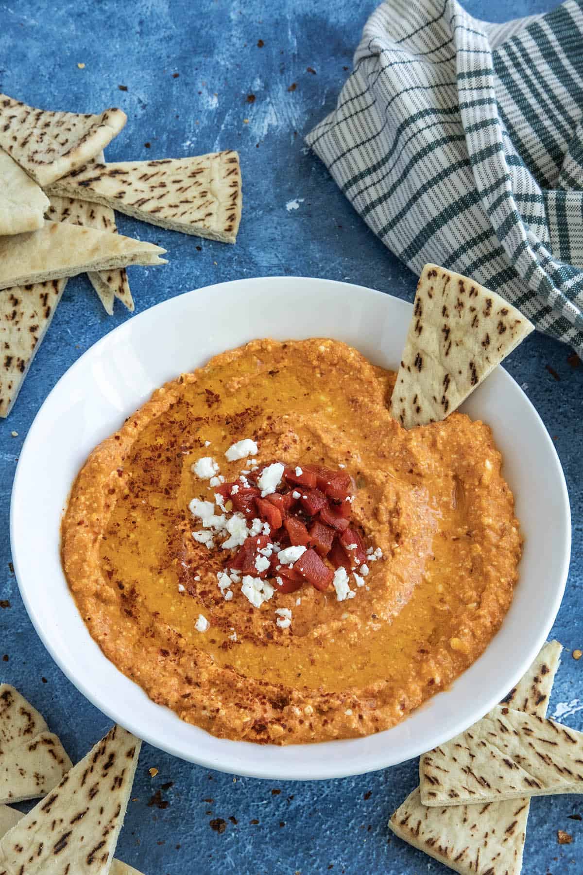 A white bowl filled with creamy Greek Whipped Feta Dip with Roasted Red Peppers (Htipiti)