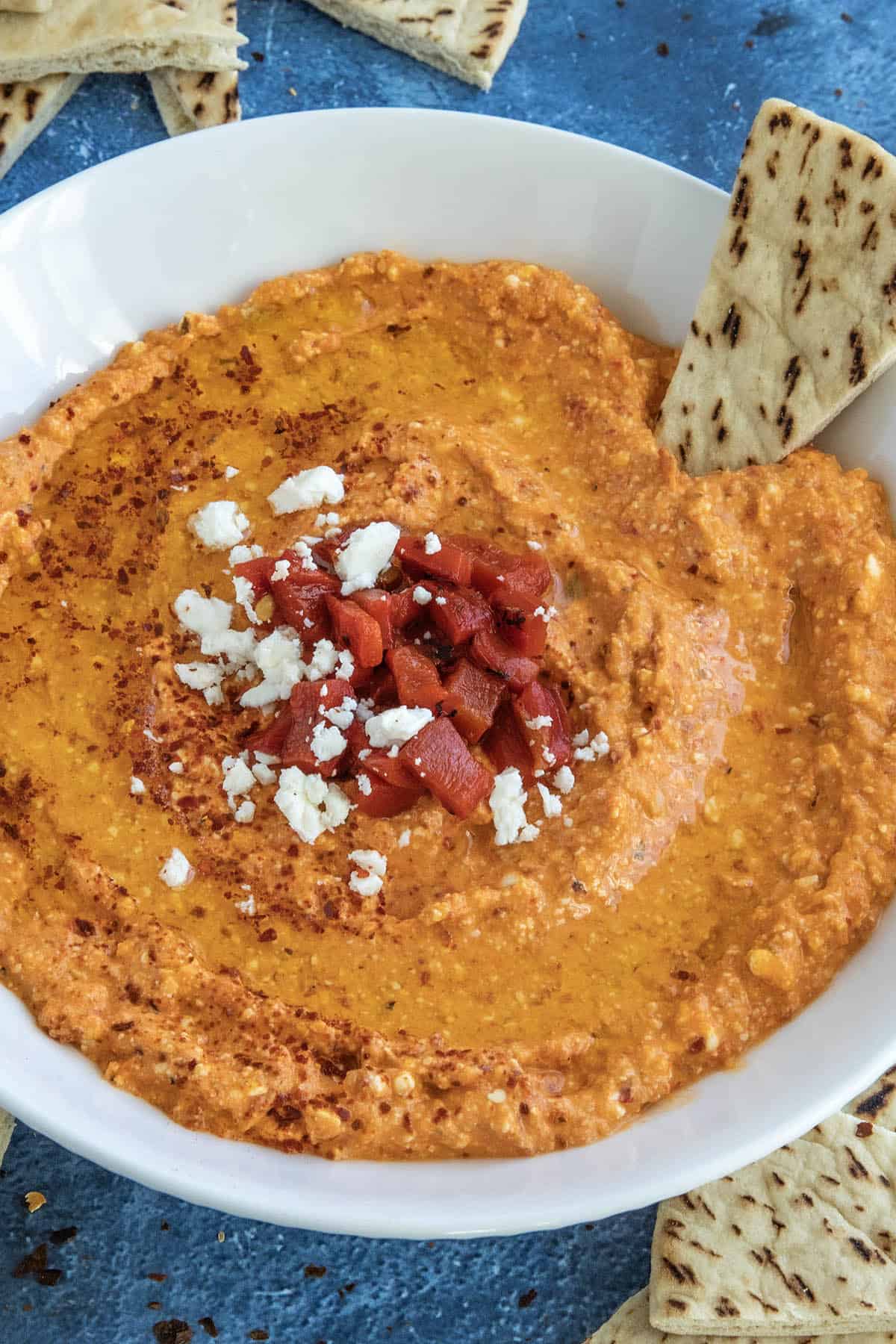 Greek Whipped Feta Dip with Roasted Red Peppers (Htipiti) in a bowl, garnished with chopped peppers and feta