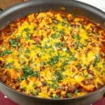 A dish of Vegetarian Enchilada Casserole served hot from the oven, garnished with chopped cilantro