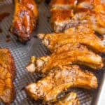 A tray of oven baked baby back ribs glazed with honey and sriracha
