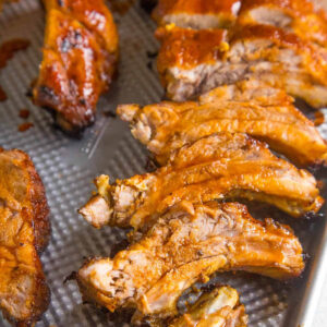 A tray of oven baked baby back ribs glazed with honey and sriracha