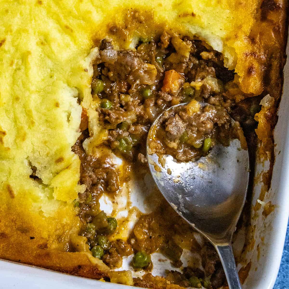Scooping a generous serving of Shepherds Pie from the baking dish
