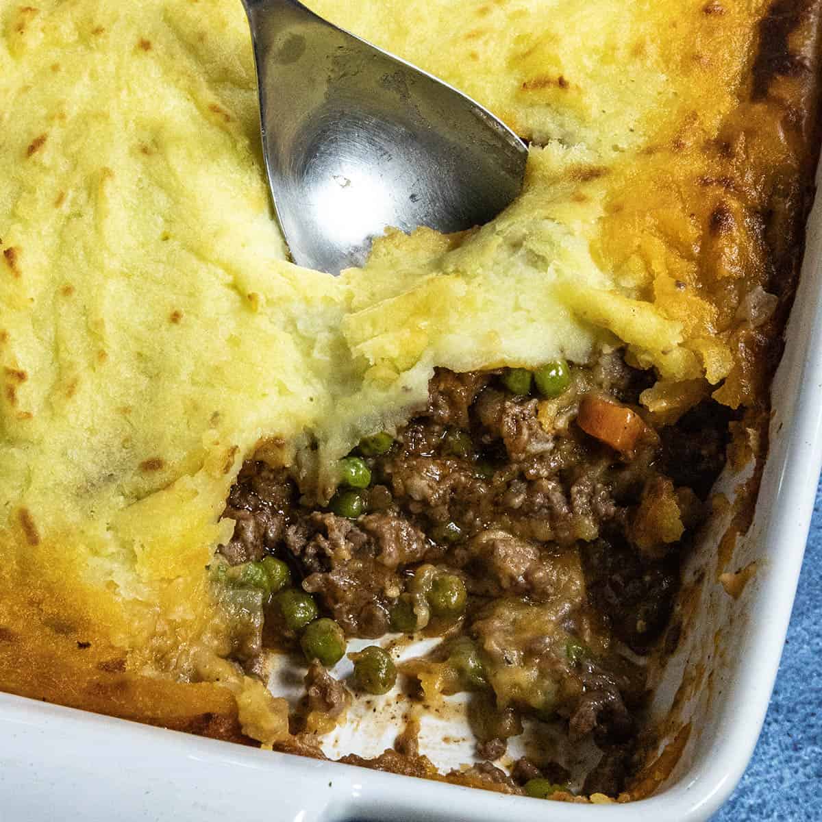 A generous scoop of Shepherds Pie taken from the baking dish