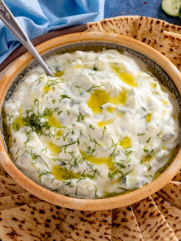Homemade Tzatziki Sauce served on a plate with slices of pita bread