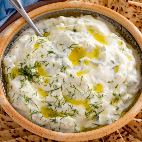 Homemade Tzatziki Sauce served on a plate with slices of pita bread