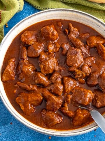 A saucy bowl filled with Mexican pork stew (asado de puerco)