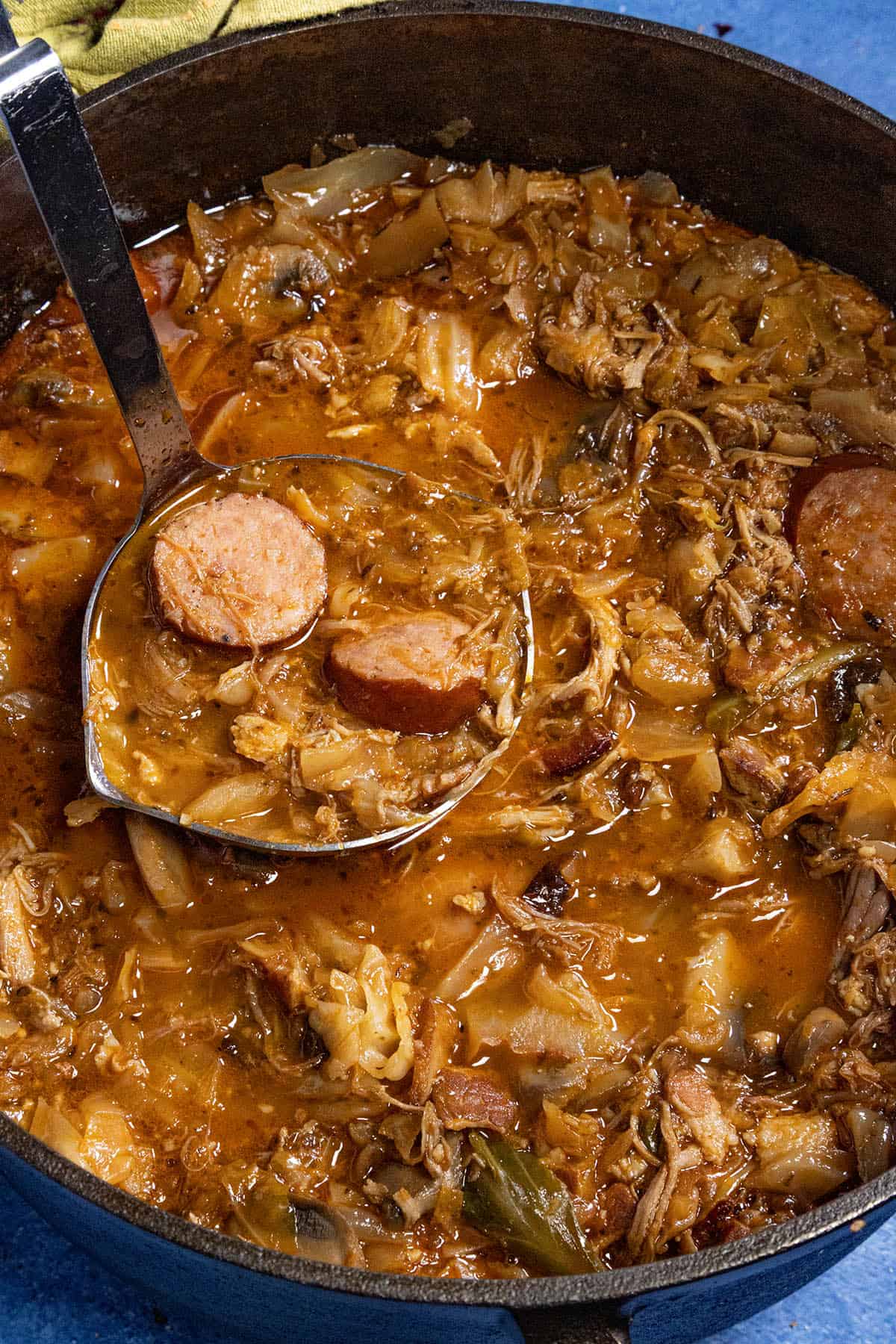 Serving a large scoop of Bigos (Polish Hunter's Stew) from the simmering pot