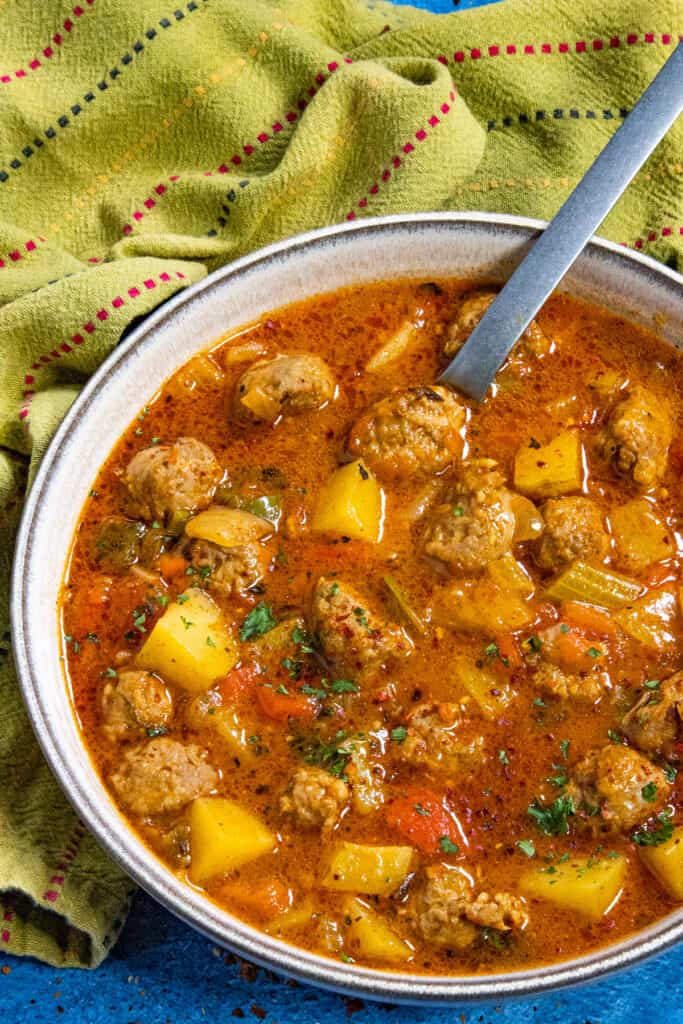 A large bowl filled with chunky Italian Sausage and Potato Soup, garnished with fresh parsley