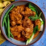 Kare Kare (Filipino Beef Stew in Peanut Sauce) in a serving bowl, topped with steamed veggies