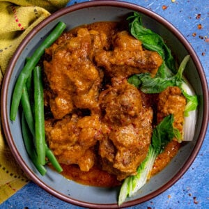 Kare Kare (Filipino Beef Stew in Peanut Sauce) in a serving bowl, topped with steamed veggies