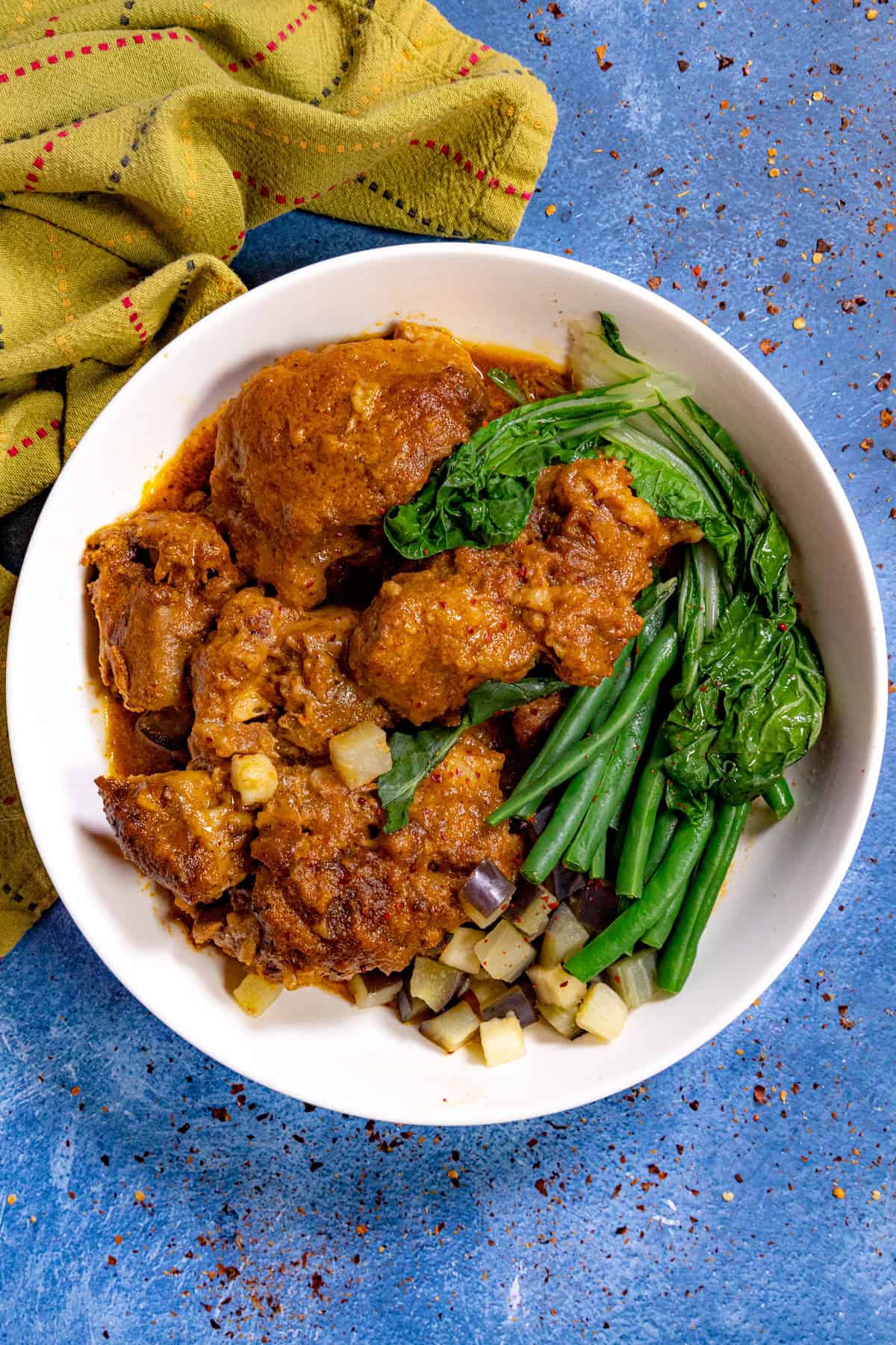 Kare Kare (Filipino Beef Stew in Peanut Sauce) in a white bowl with vegetables