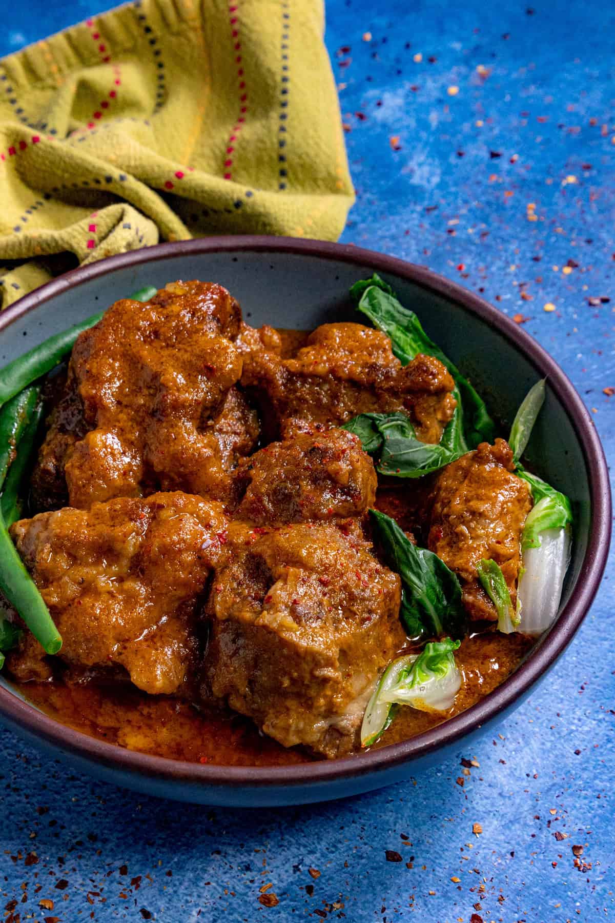 A bowl filled with Kare Kare (Filipino Beef Stew in Peanut Sauce)