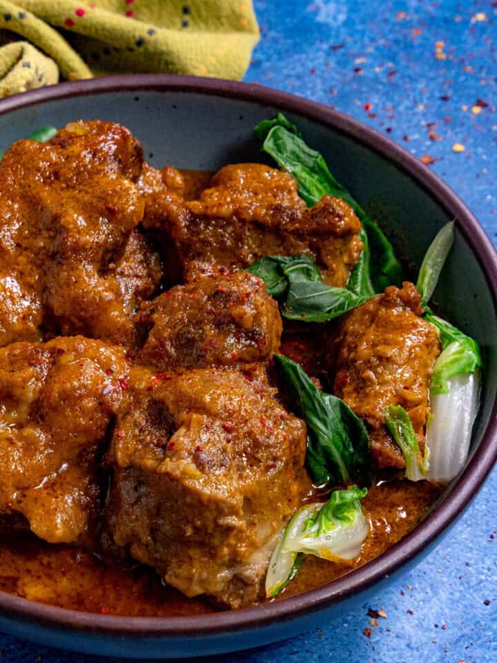 A bowl filled with Kare Kare (Filipino Beef Stew in Peanut Sauce)