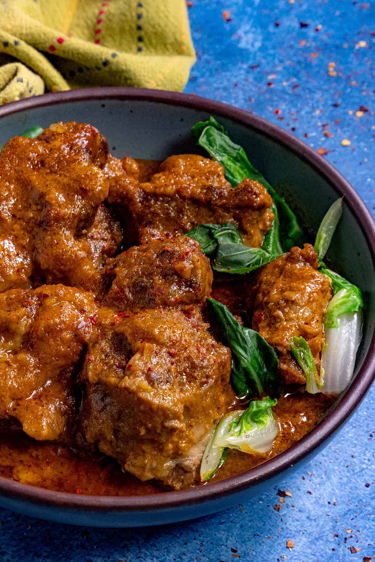 A bowl filled with Kare Kare (Filipino Beef Stew in Peanut Sauce)