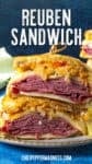 A close-up of a Reuben Sandwich cut in half, stacked with layers of corned beef, Swiss cheese, sauerkraut, and dressing on toasted rye bread. The classic Reuben Sandwich is held together with a toothpick.