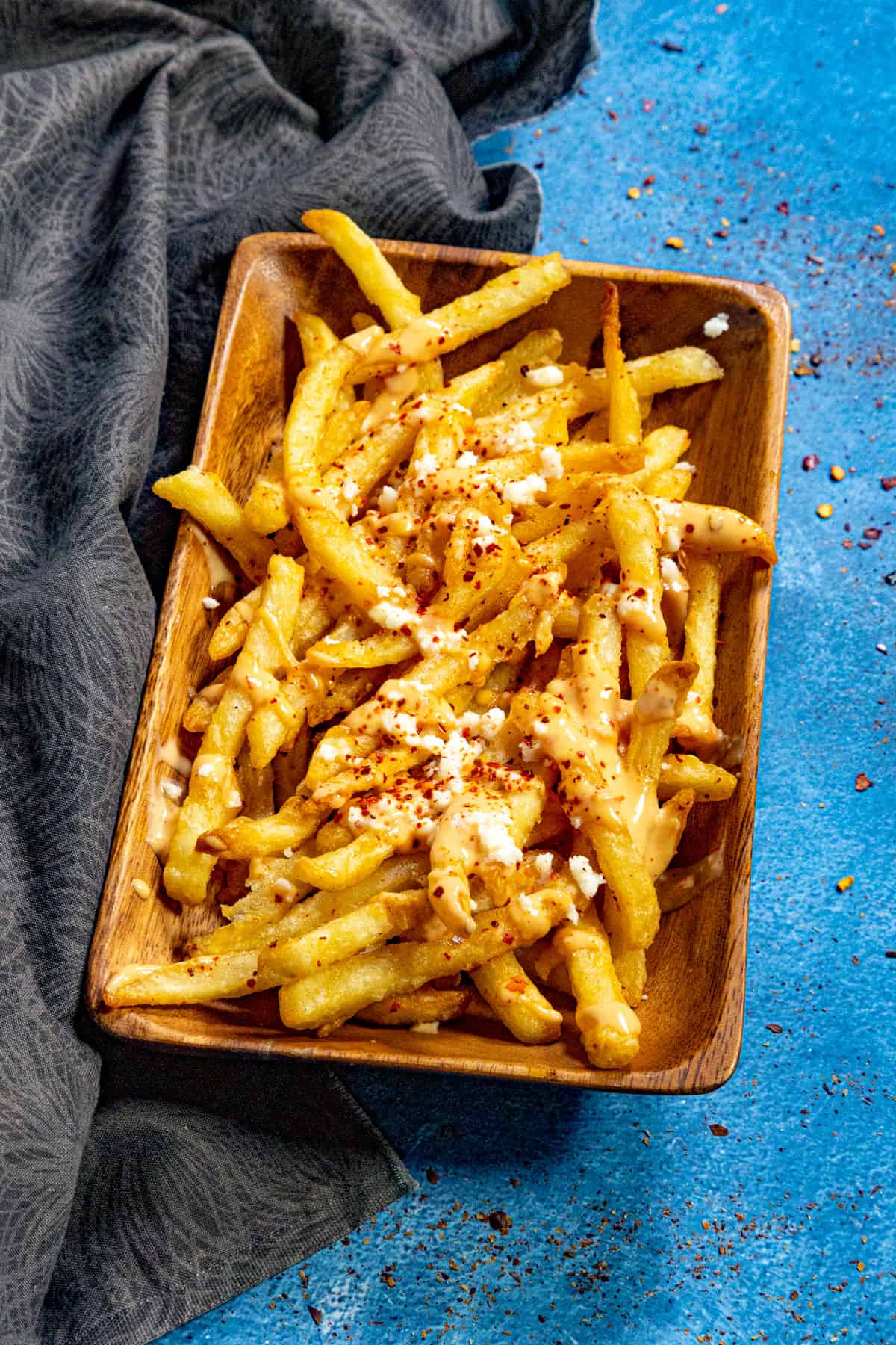 A basket of crispy French fries drizzled with creamy, spicy Belgian samurai sauce