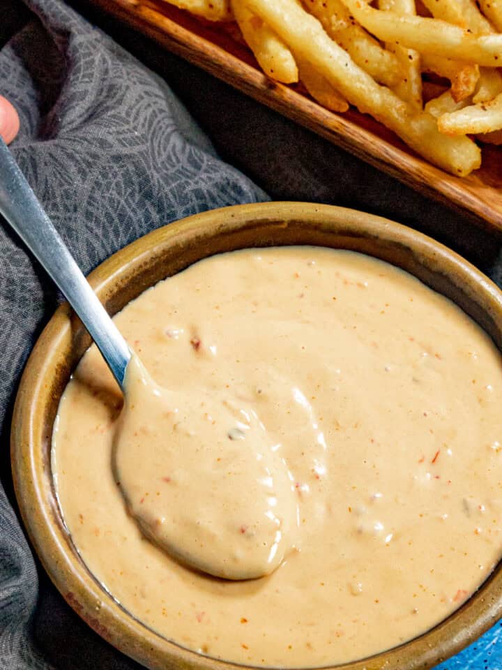 A bowl filled with creamy samurai sauce, with french fries on the side