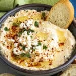 A bowl of Greek Spicy Feta Dip (Tirokafteri) topped with feta cheese and olive oil