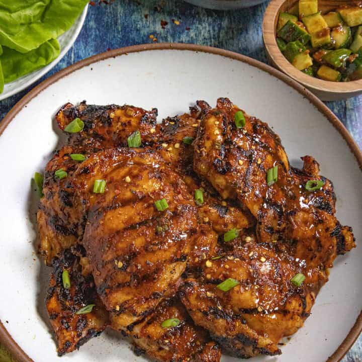 Dak Bulgogi (Korean BBQ Chicken) served on a plate with a bowl of rice and kimchi on the side