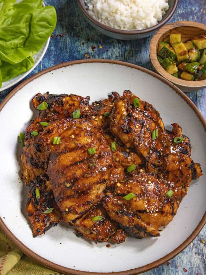 Dak Bulgogi (Korean BBQ Chicken) served on a plate with a bowl of rice and kimchi on the side