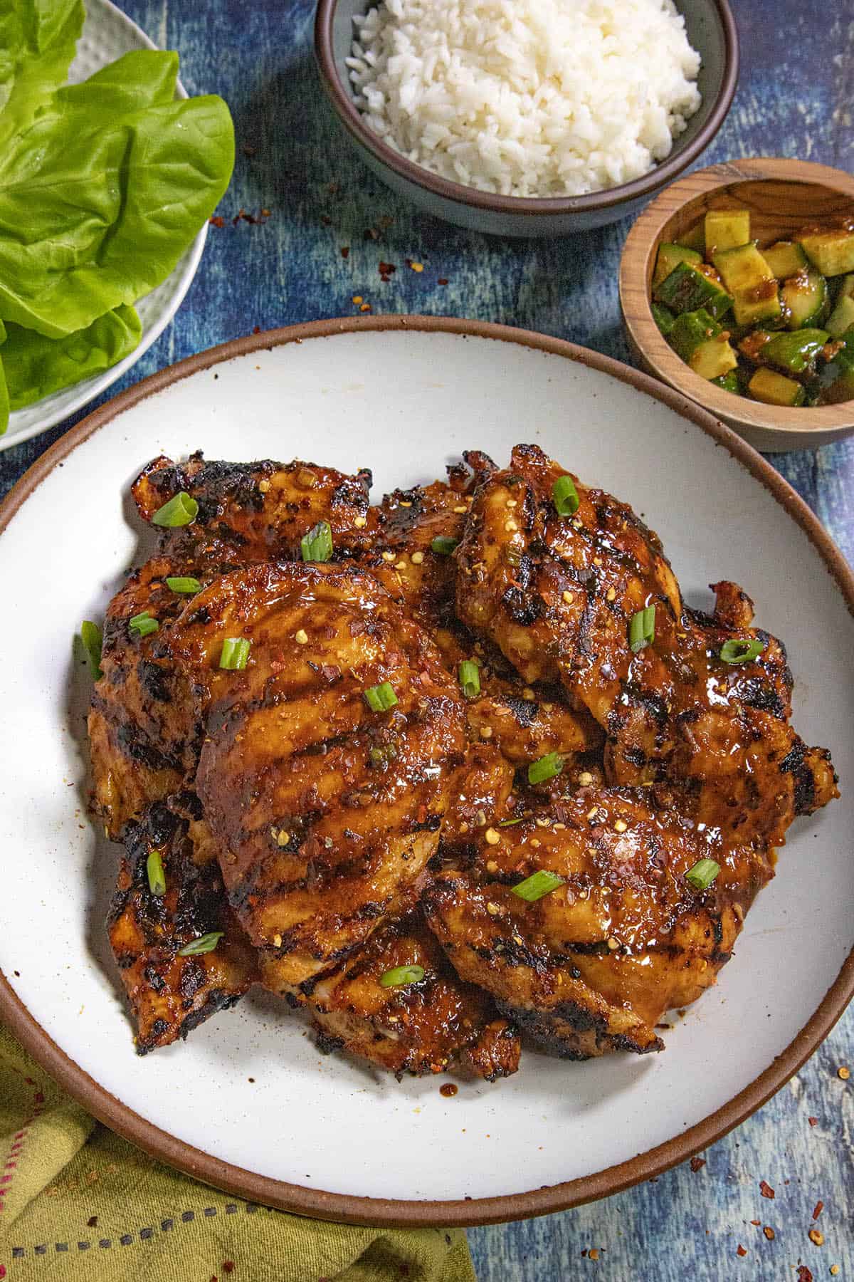 Dak Bulgogi (Korean BBQ Chicken) served on a plate with a bowl of rice and kimchi on the side