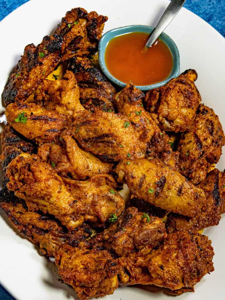 Cowboy butter chicken wings piled up on a serving dish, served with a bowl of cowboy butter on the side