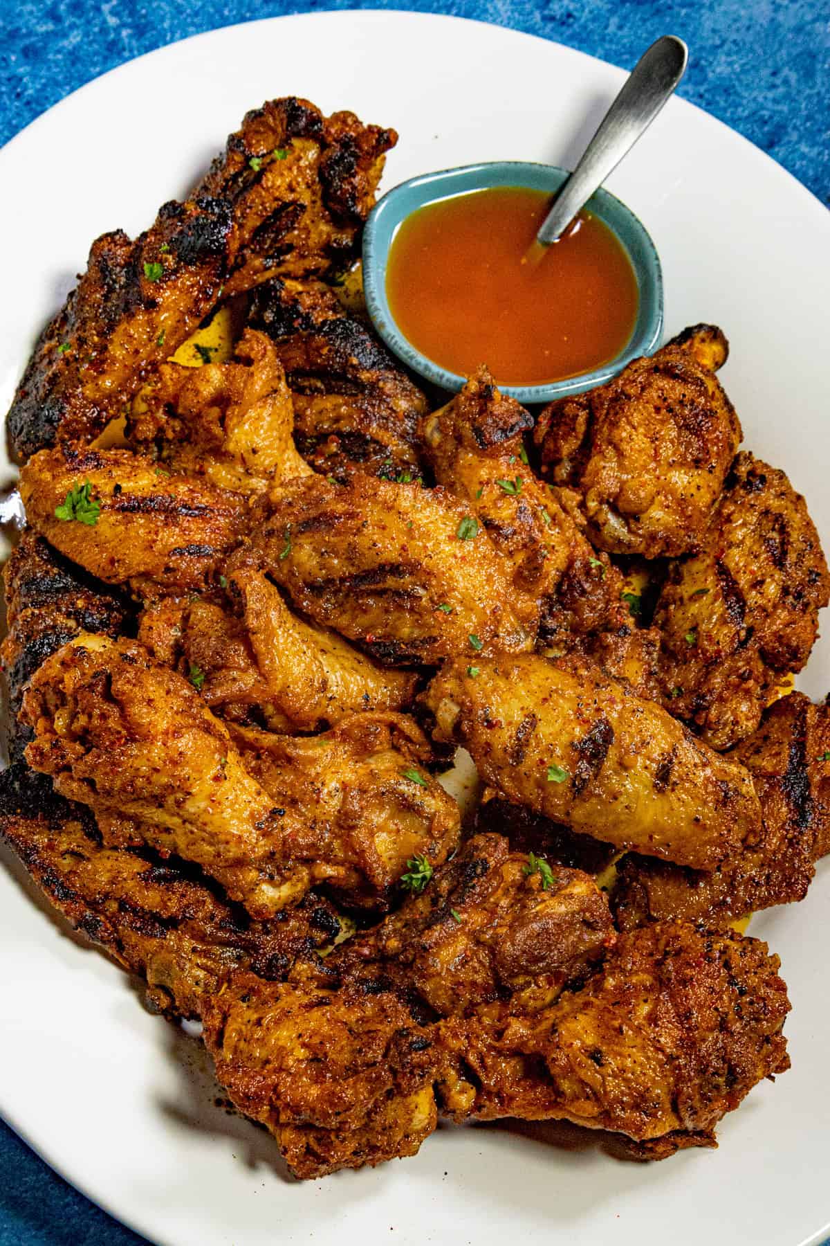 Cowboy butter chicken wings piled up on a serving dish, served with a bowl of cowboy butter on the side