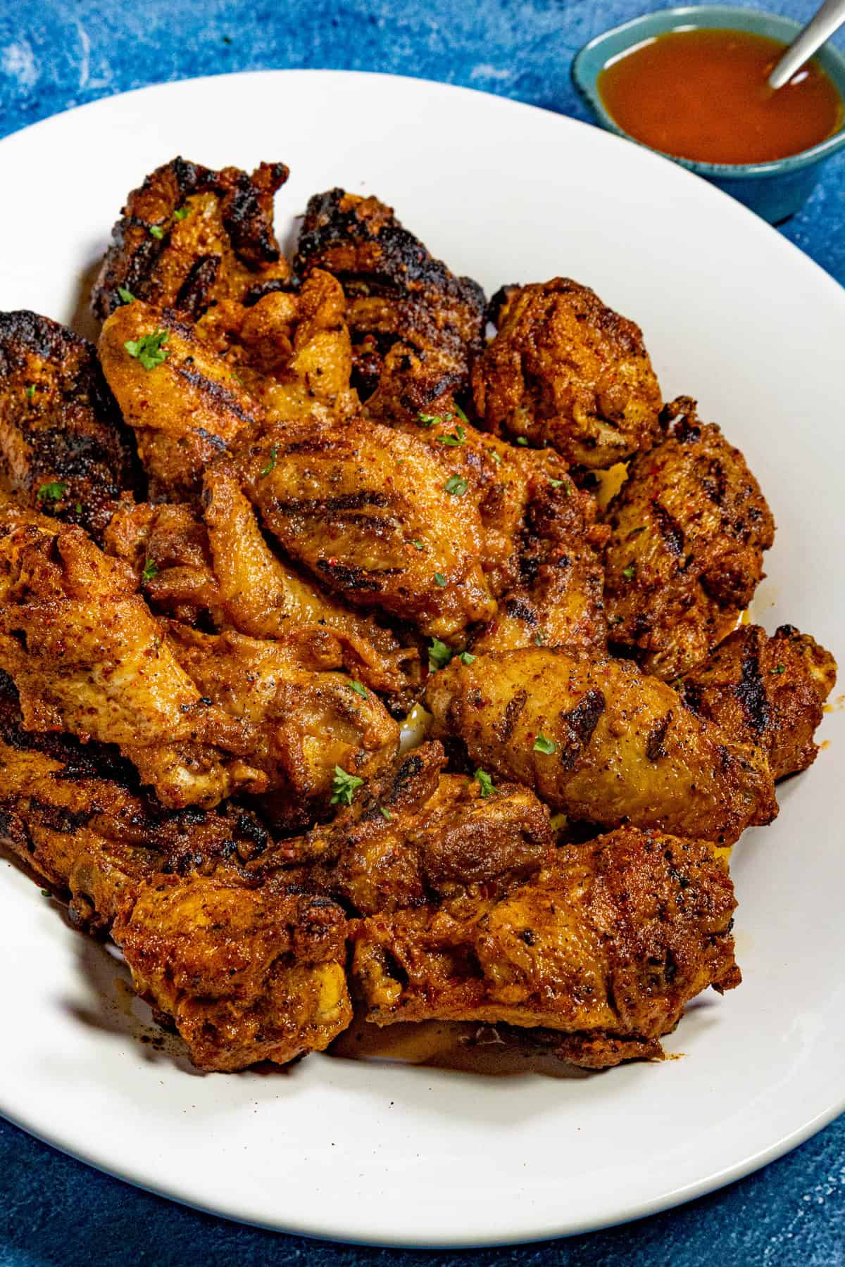 12 juicy grilled chicken wings served on a large platter, glistening with spiced cowboy butter