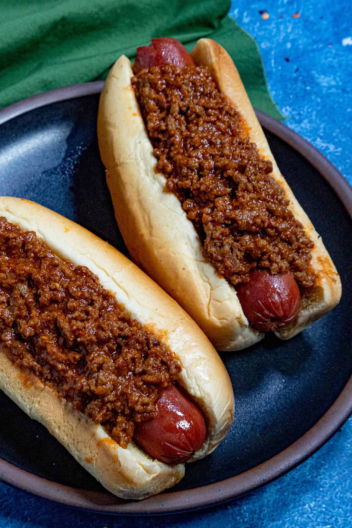 Two chili dogs on a plate, ready to serve