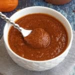 A bowl filled with spicy habanero-honey bbq sauce, with a serving spoon