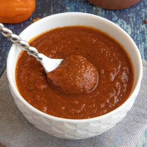 A bowl filled with spicy habanero-honey bbq sauce, with a serving spoon