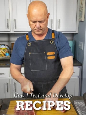 Mike from Chili Pepper Madness testing recipes in the kitchen, cutting meat on a cutting board
