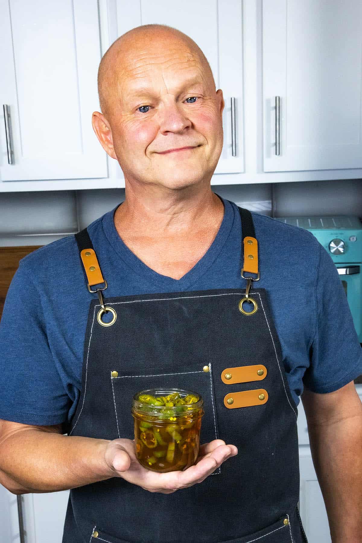 Mike from Chili Pepper Madness holding a jar of homemade candied jalapenos (aka Cowboy Candy)