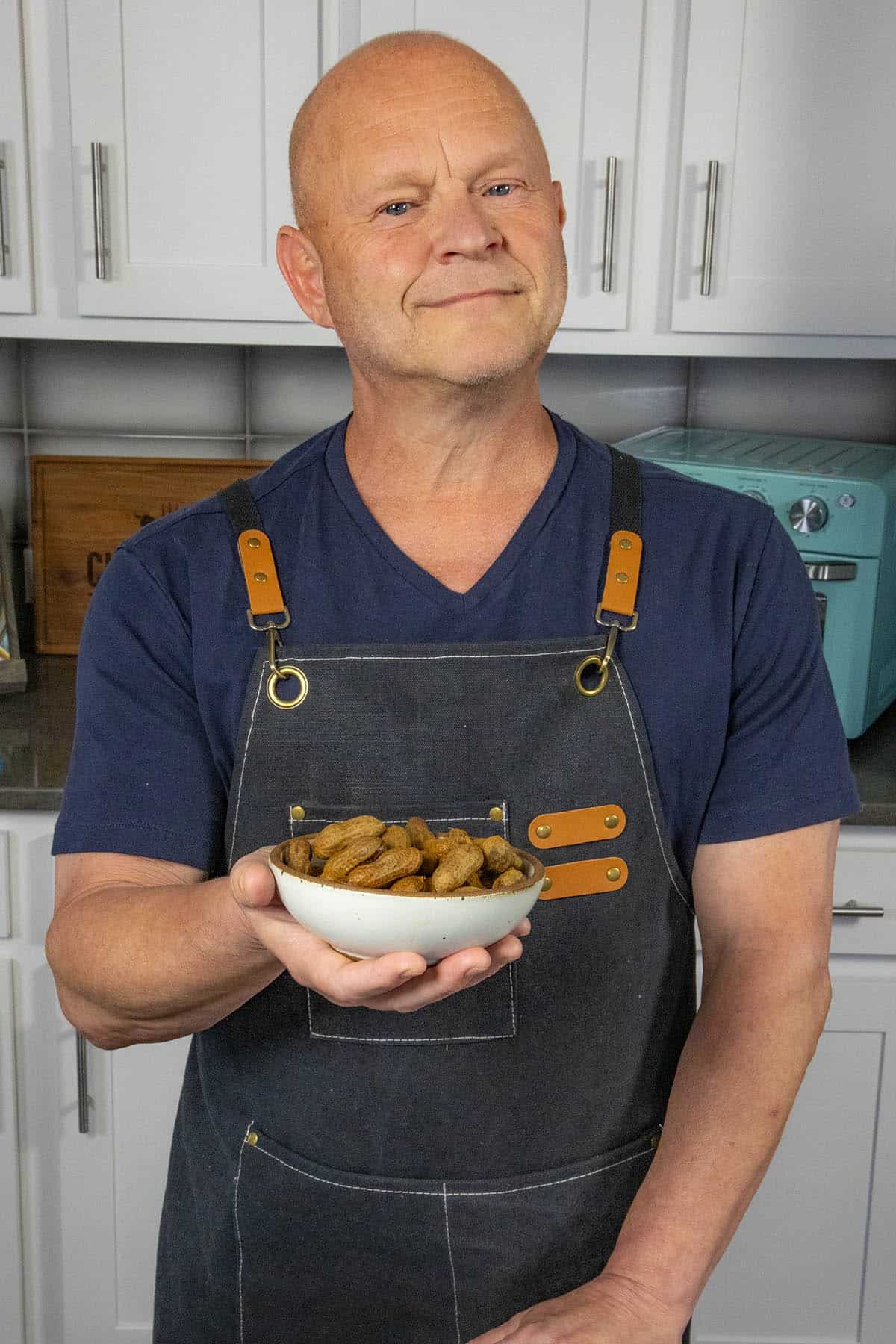 Mike from Chili Pepper Madness holding a bowl of spicy homemade boiled peanuts
