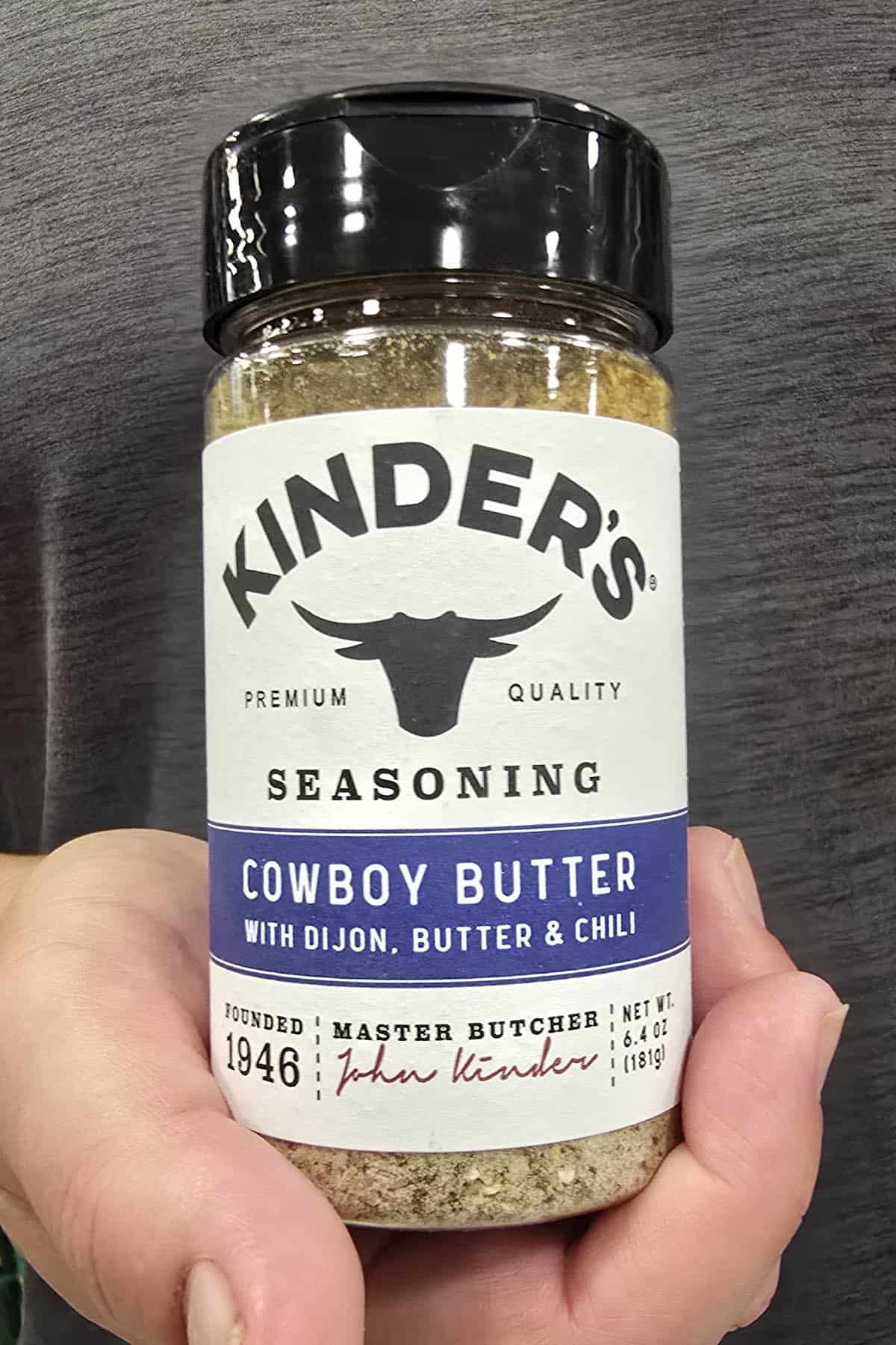 Mike from Chili Pepper Madness holding a container of Kinder's Cowboy Butter Seasoning