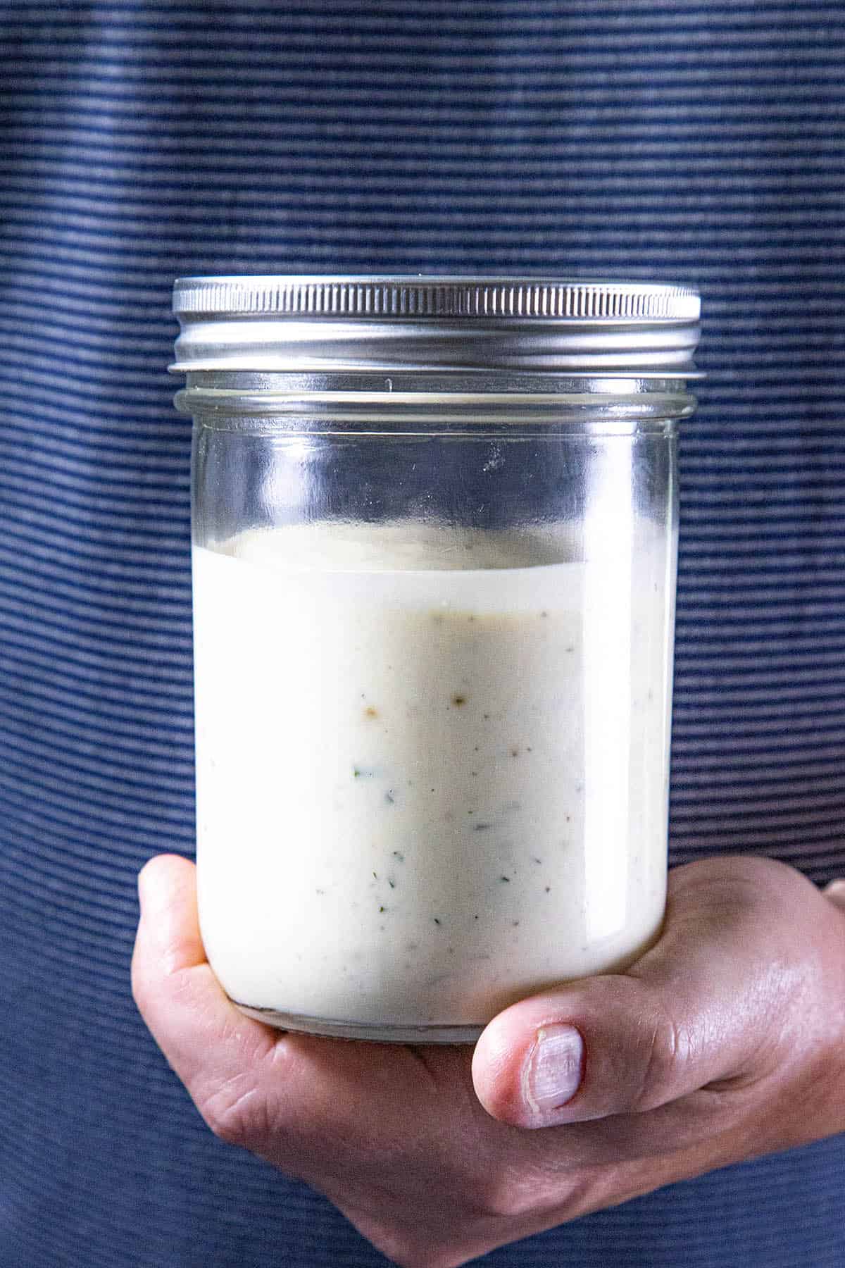 Mike from Chili Pepper Madness holding a jar of cream Homemade Ranch Dressing