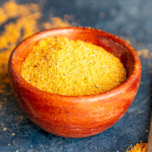 A small wooden bowl filled with homemade Vindaloo masala (curry spice), perfect for quick and easy vindaloo dishes.