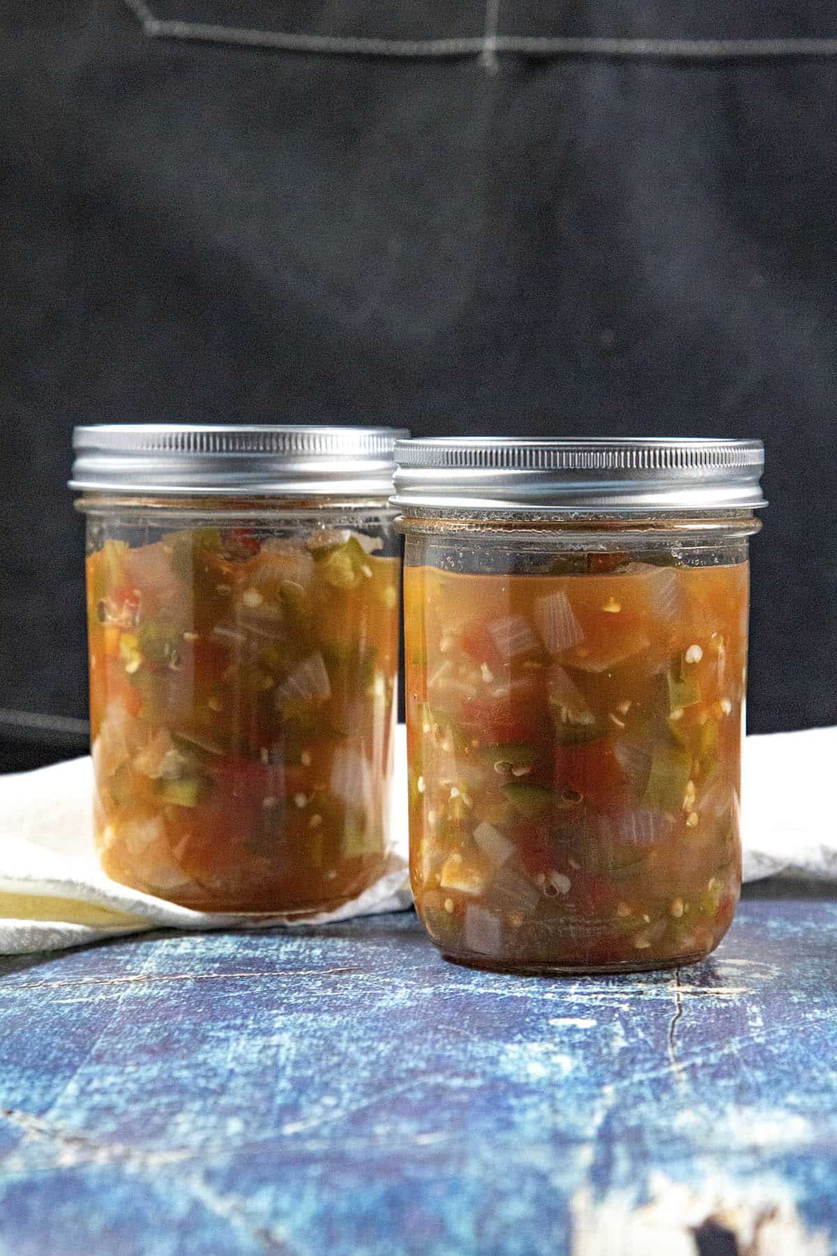 Two jars of canned salsa sitting on a table