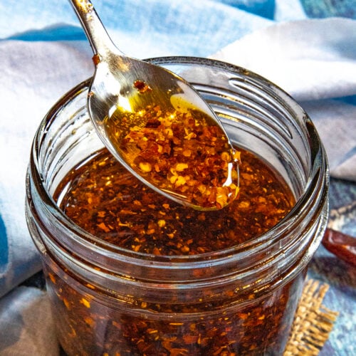 Lifting a spoonful of Calabrian Chili Oil (Olio Santo) from a jar
