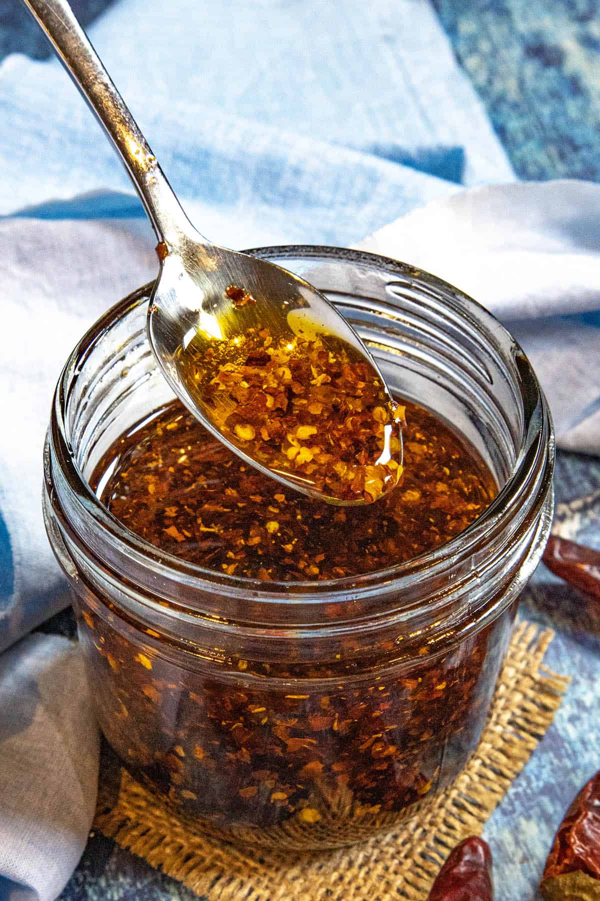 Lifting a spoonful of Calabrian Chili Oil (Olio Santo) from a jar