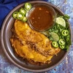 Four Chicken Birria Tacos (Birria de Pollo) on a plate, served with birria consome dipping sauce