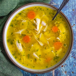 A bowl of golden Homemade Chicken Noodle Soup served with a spoon