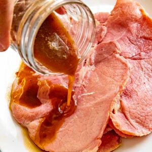 Pouring red eye gravy over country ham on a plate